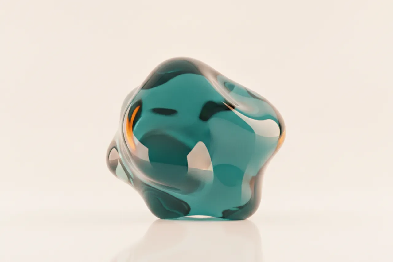 Iridescent glass sculpture refracting teal light